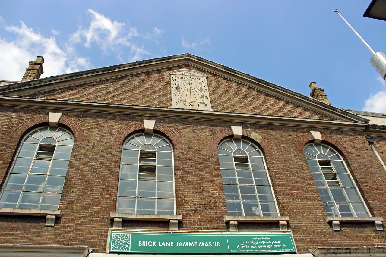 The brick facade and sundial of Brick Lane Jamme Masjid, east London