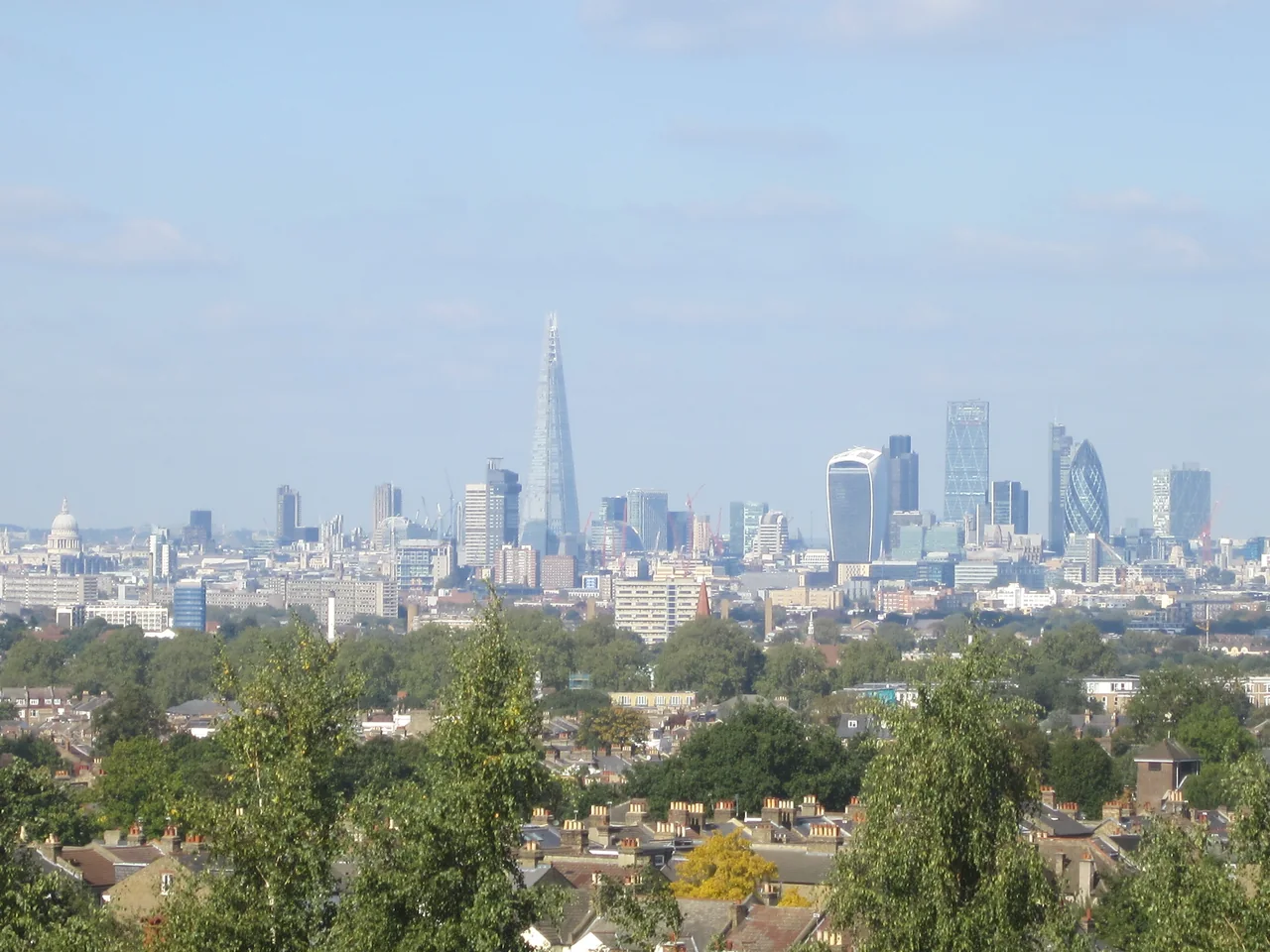 The City of London skyline, with the Shard and the City towers, seen across the rooftops of south London