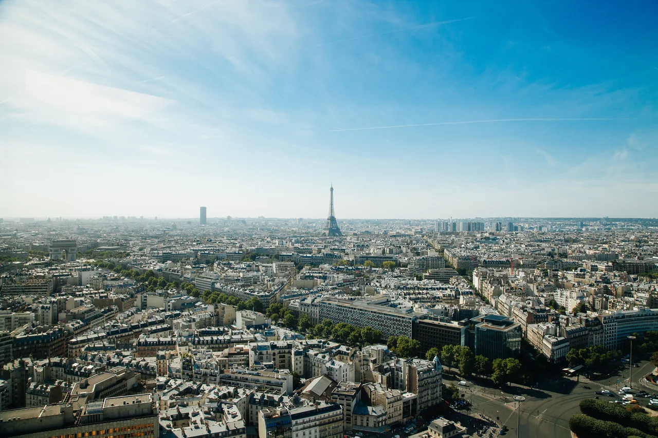 The Paris skyline at midday, the Eiffel Tower on the horizon above the rooftops