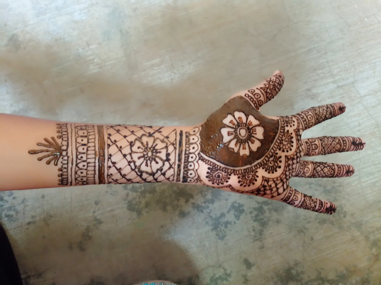 A hand and forearm patterned with henna